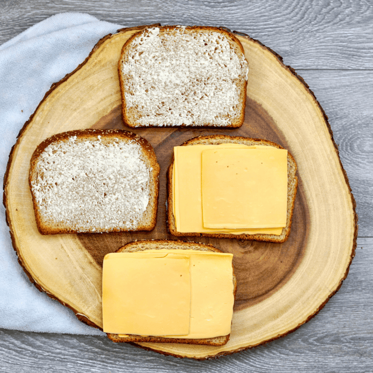 Grilled cheese sandwich cooking in skillet with cheese melting inside