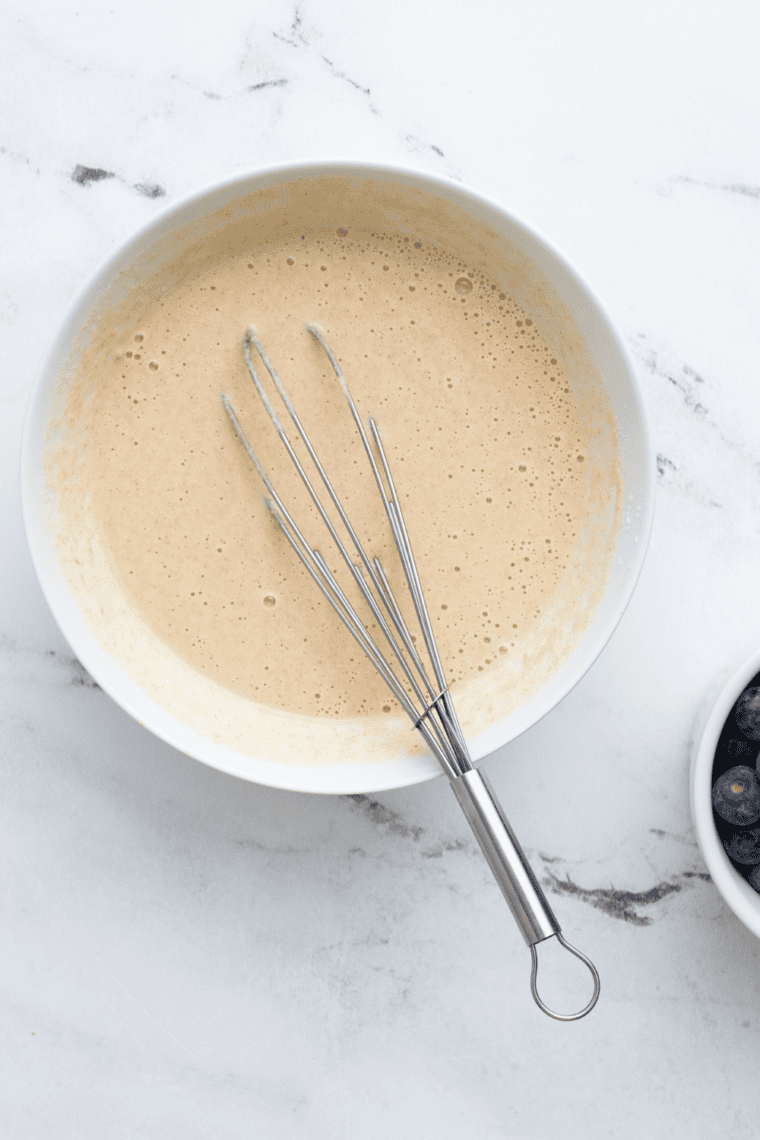 Whisking dry ingredients for lemon ricotta pancake batter in mixing bowl