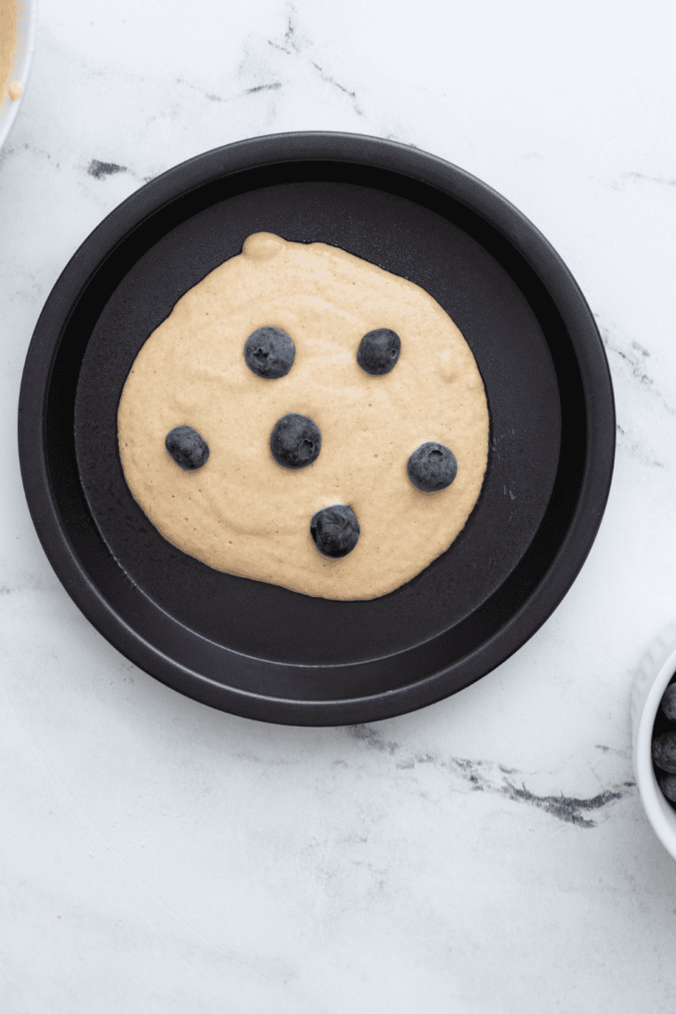 Pouring pancake batter onto buttered skillet for cooking