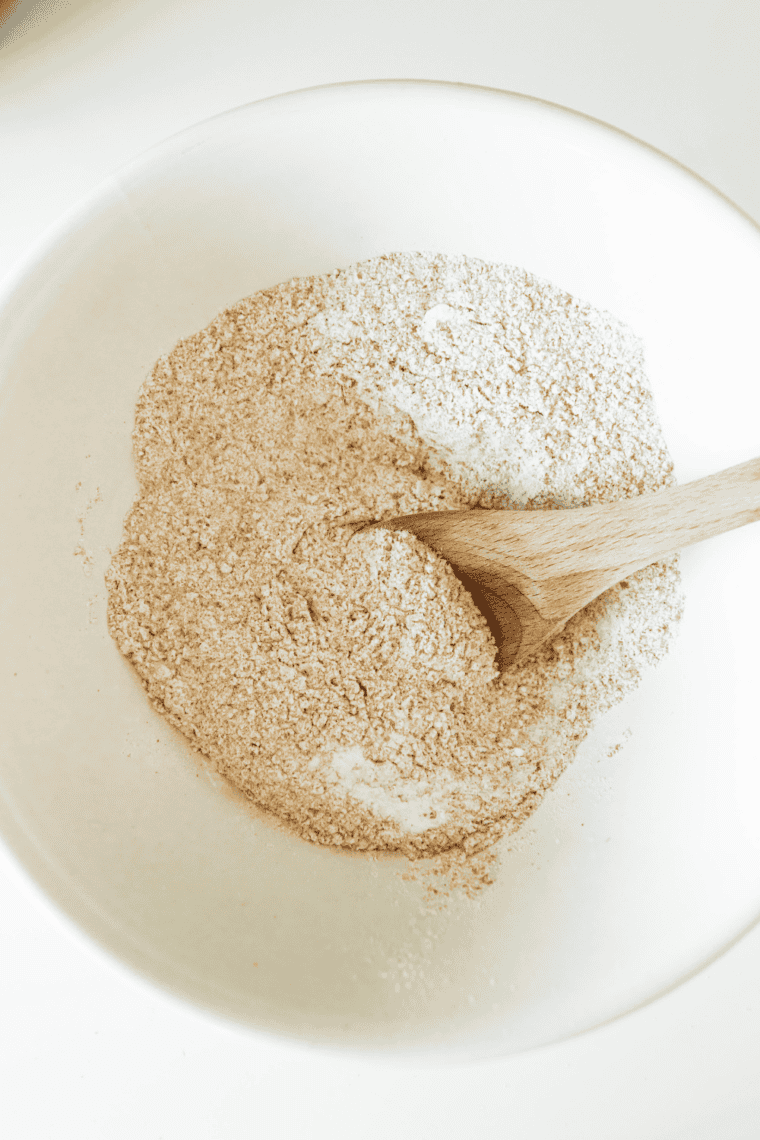 Large bowl with all-purpose flour, whole wheat flour, oats, sunflower and flax seeds, and salt.