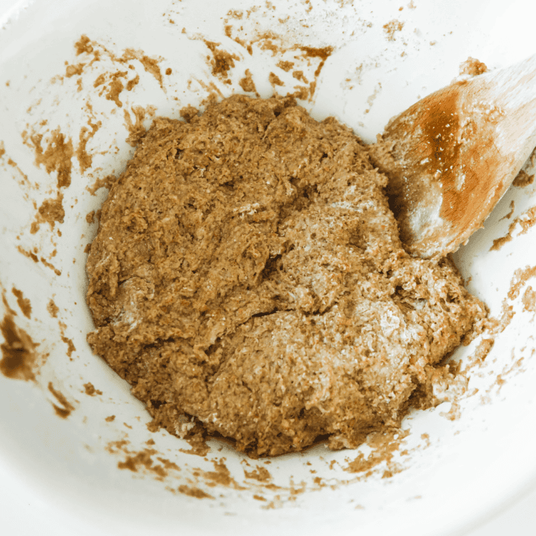 Punching down dough and shaping it into a loaf in greased loaf pan.