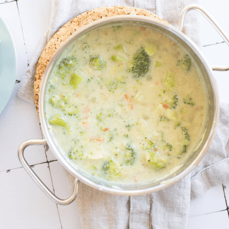 Bowl of creamy McAlister&rsquo;s Broccoli and Cheddar Soup topped with melted cheddar cheese and tender broccoli florets in a thick, rich, golden cheese base.