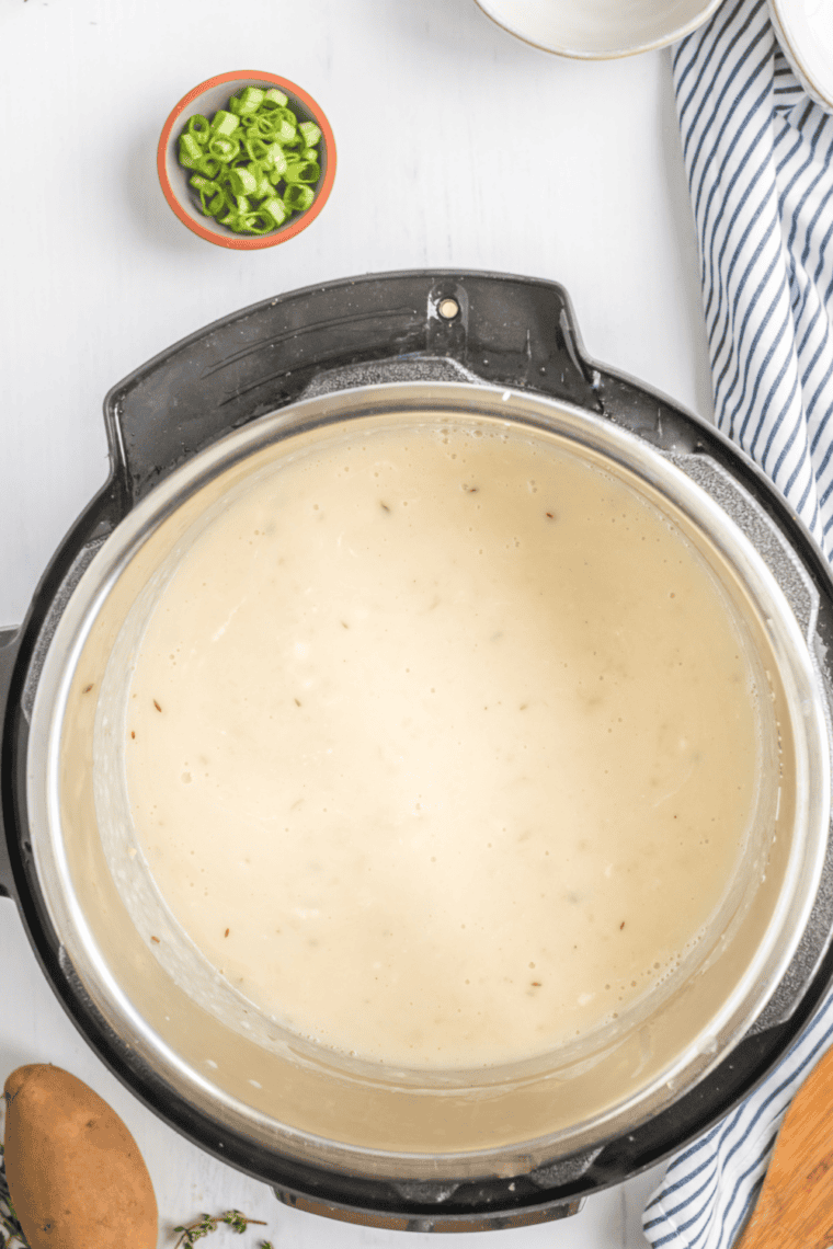 Loaded potato soup topped with crispy bacon and green onions in bowl