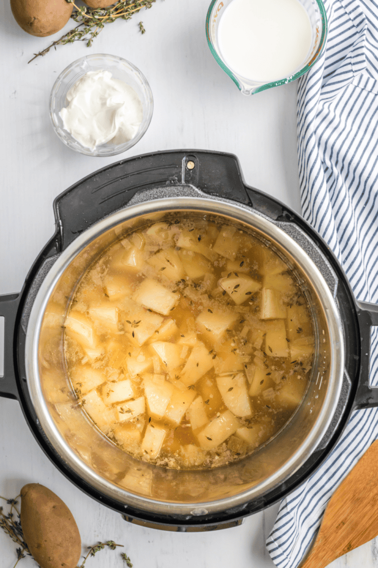 Chicken broth milk and diced potatoes added to Instant Pot soup mixture