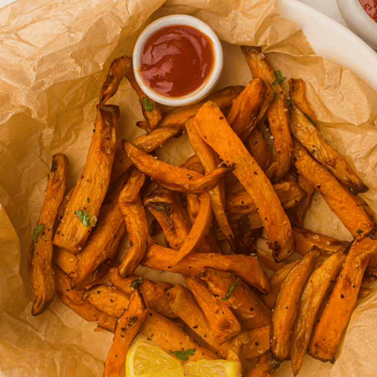 Golden, crispy sweet potato fries cooked in a Ninja Crispi air fryer, served on a plate.