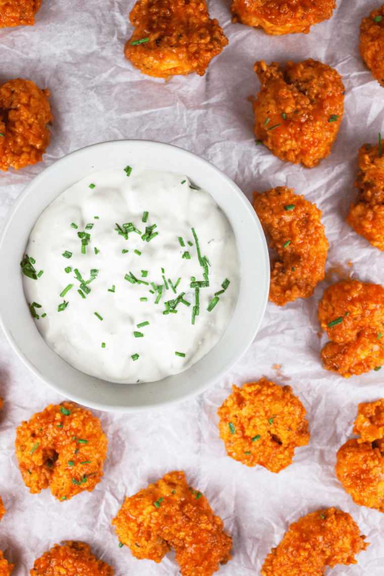 Creamy homemade ranch dressing in a bowl with fresh herbs, served with fries and vegetables for dipping