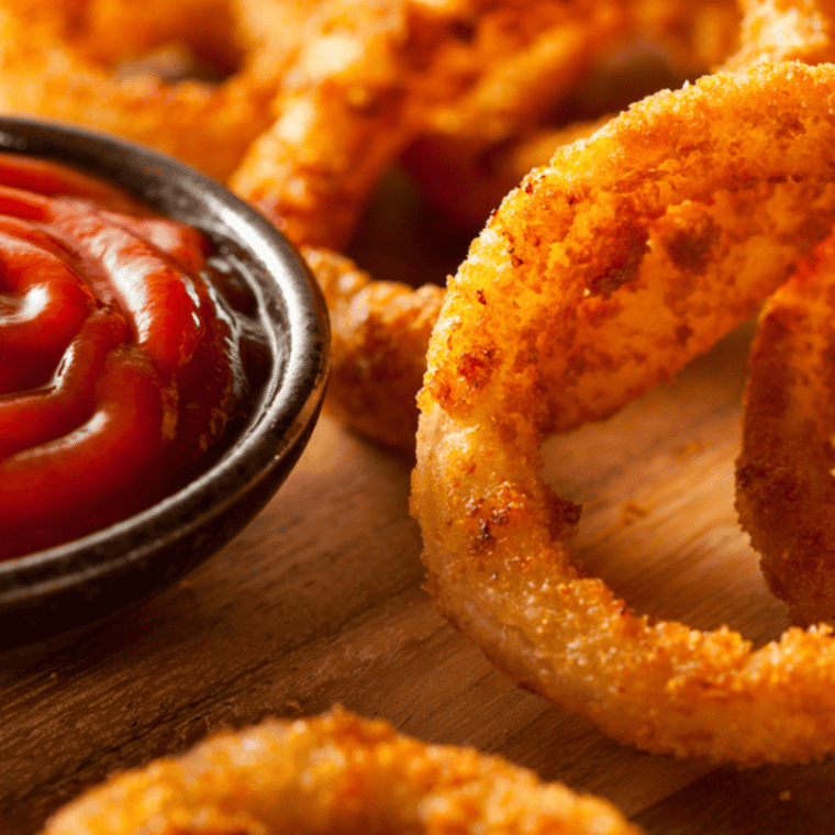 Homemade Red Robin spicy ketchup in a small bowl served with crispy fries for dipping, bold red dipping sauce with sweet and spicy flavor