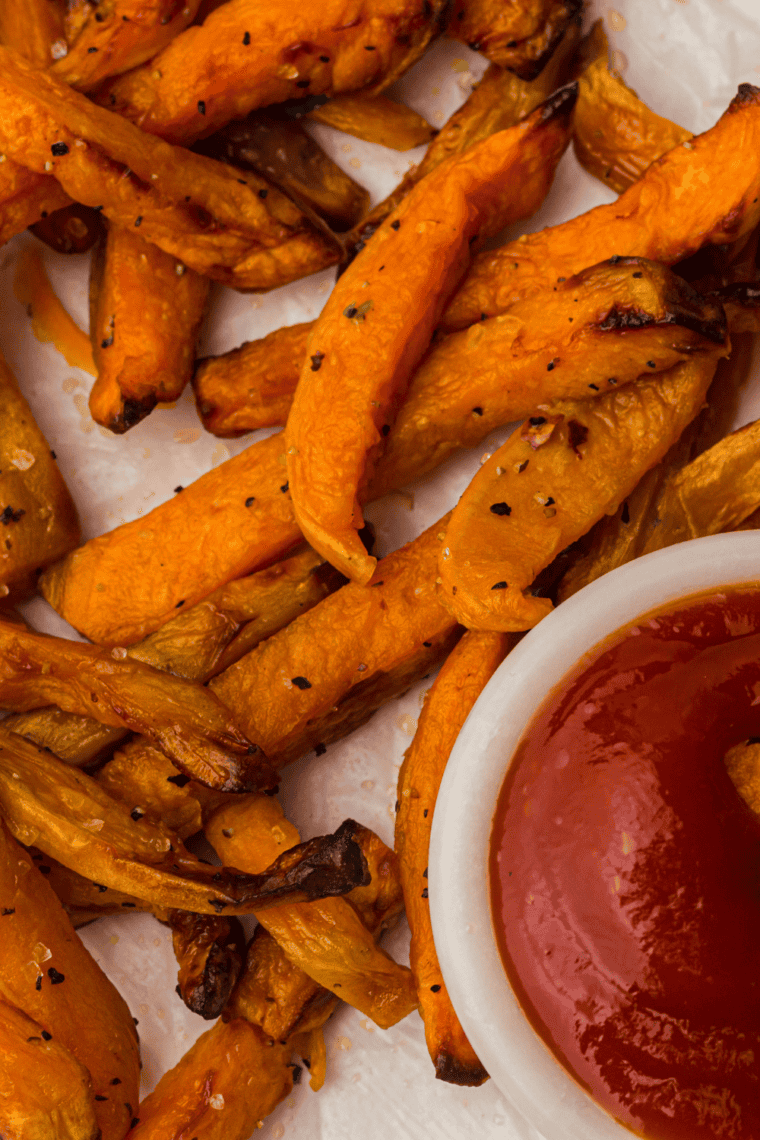 Homemade Red Robin spicy ketchup served in a bowl with crispy fries for dipping, smooth red sauce with sweet heat flavor