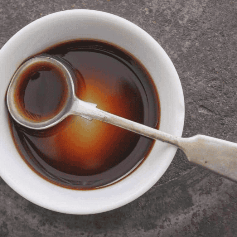 Glossy homemade teriyaki sauce in a bowl with sweet and savory glaze texture, served with grilled chicken, rice, and vegetables for dipping and drizzling.