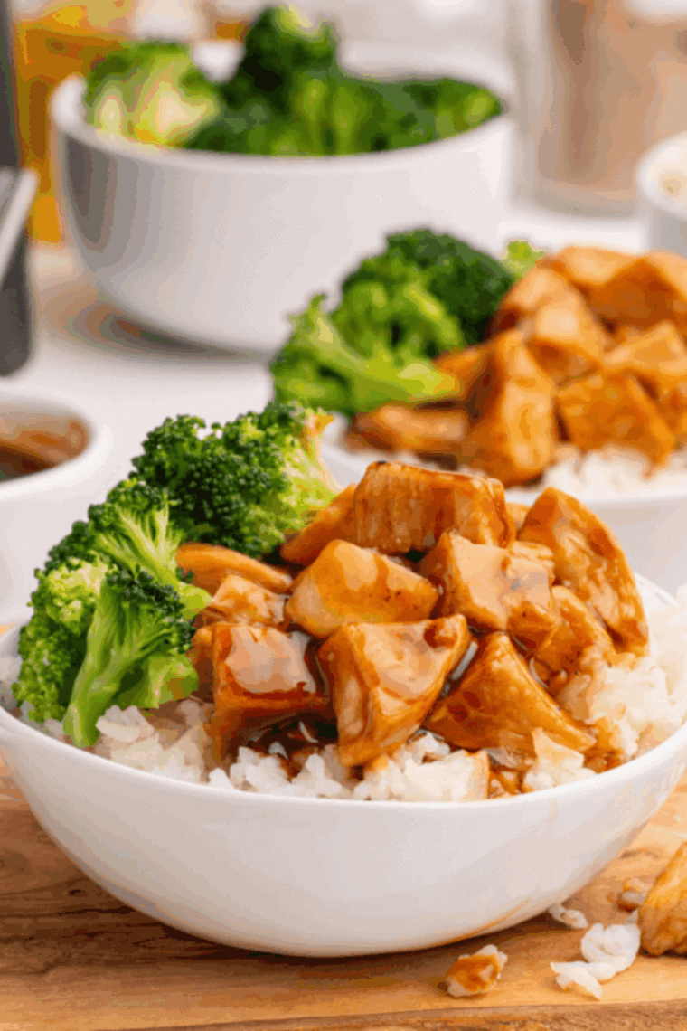 Glossy homemade teriyaki sauce in a bowl with rich sweet and savory glaze texture, served with grilled chicken, rice, and vegetables for drizzling or dipping.