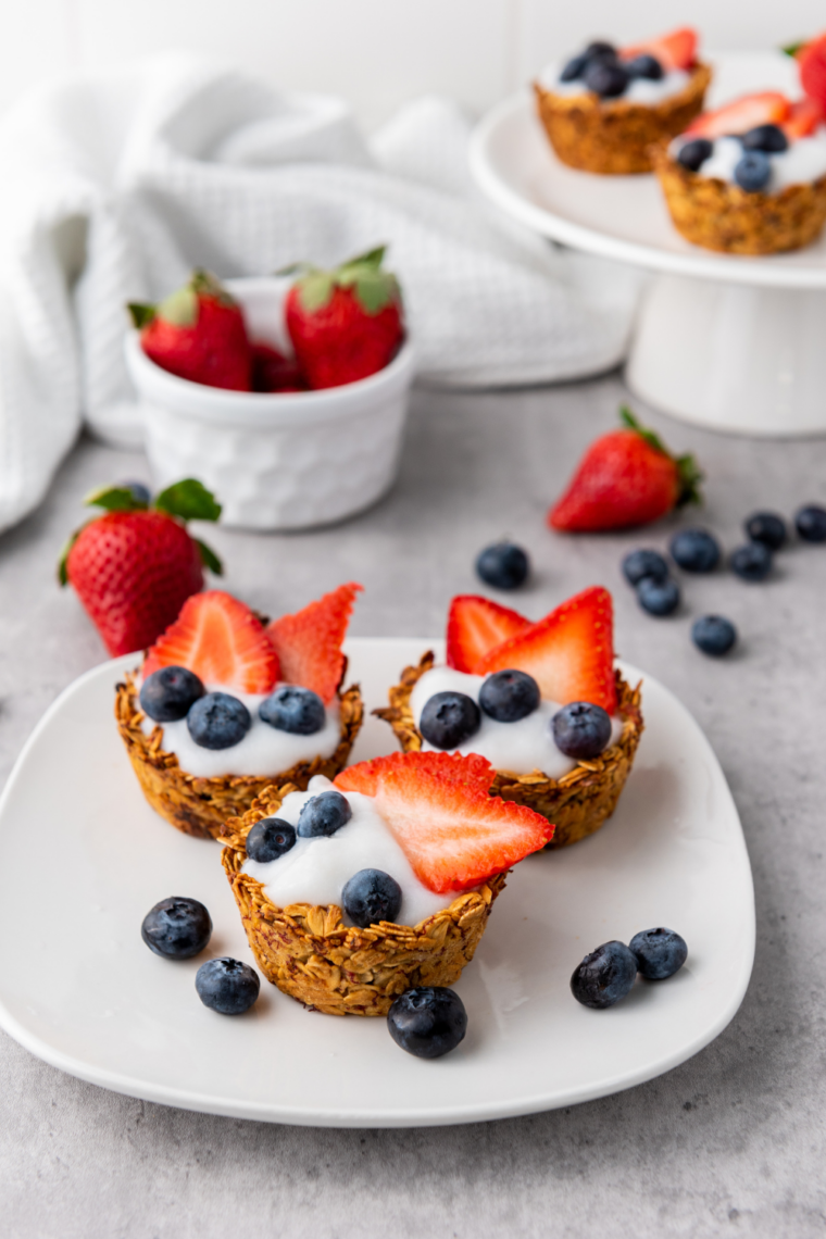 Red white and blue granola berry cups layered with yogurt granola strawberries and blueberries in clear cups