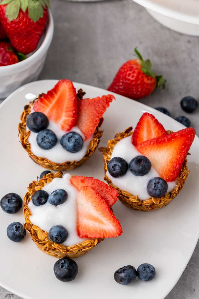 Close up of patriotic granola berry cups with layered yogurt strawberries and blueberries in serving cups