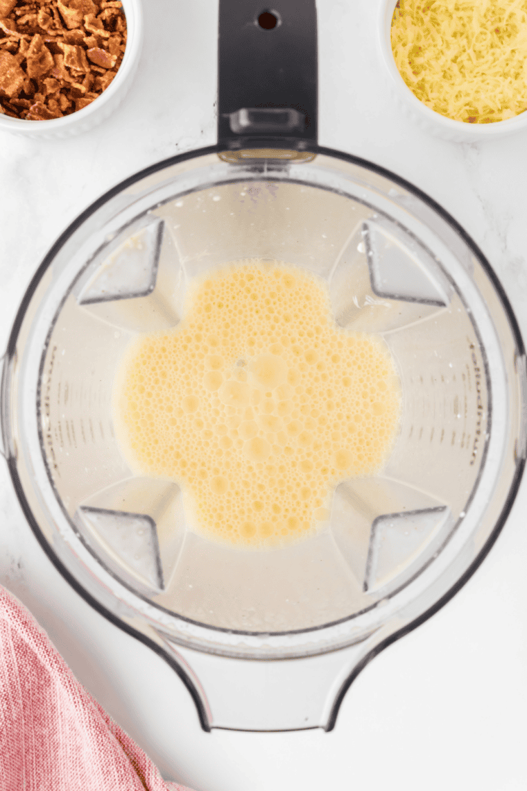 Whisking eggs, cream, salt, and pepper in a bowl until smooth and slightly frothy.