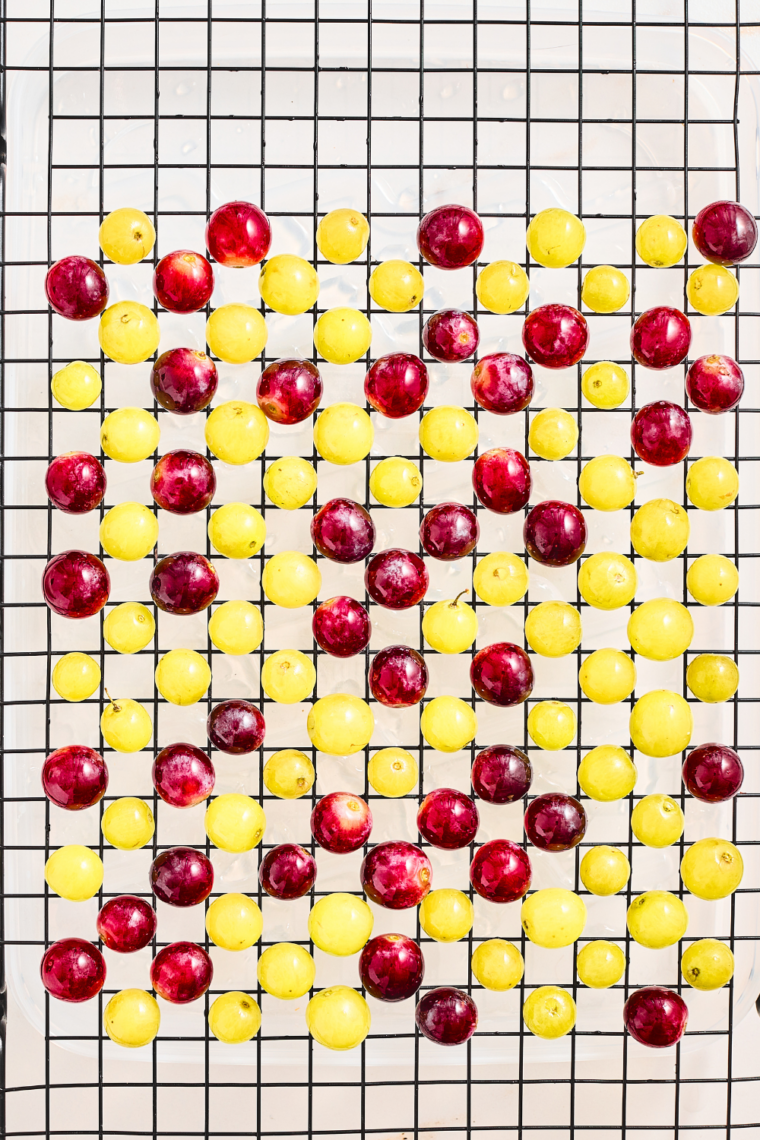 Tacky grapes being rolled in granulated sugar for a frosted coating