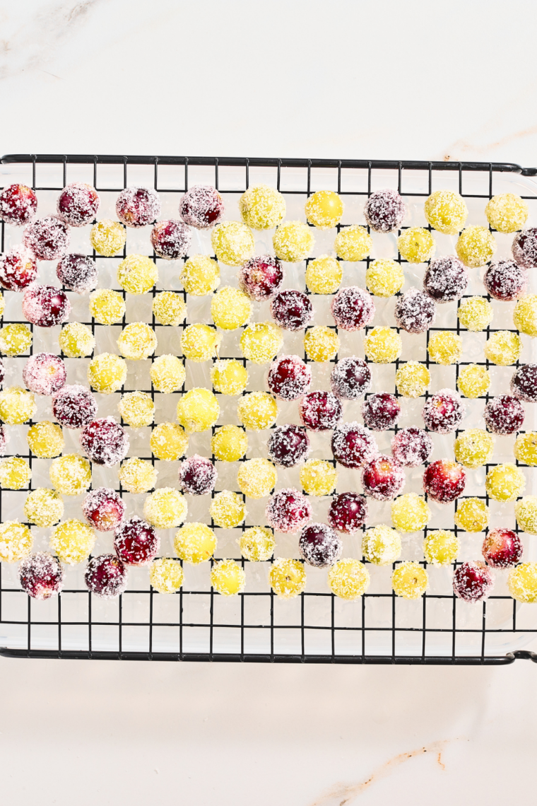 Sugar coated grapes chilling on a parchment lined tray until set and ready to serve