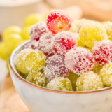 Sugar coated grapes in a bowl with a sparkling sugar coating on fresh green grapes