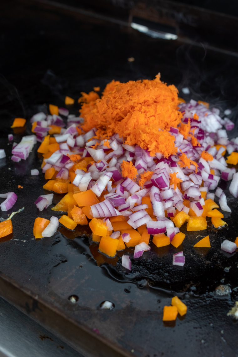 Beaten eggs scrambling quickly on hot griddle until soft and fluffy pieces form