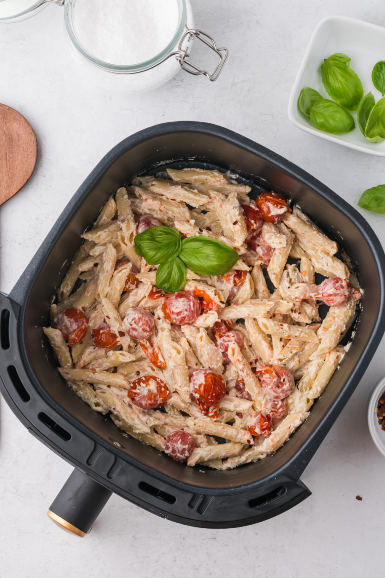 air fryer dish with bubbling tomato sauce and softened cheese cooking