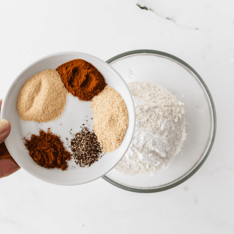 Small bowl of mixed spices being whisked together into a uniform seasoning blend for Zaxby&rsquo;s fry seasoning.