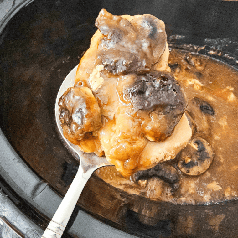 Slow cooker pork chops smothered in creamy gravy with a rich, golden finish.