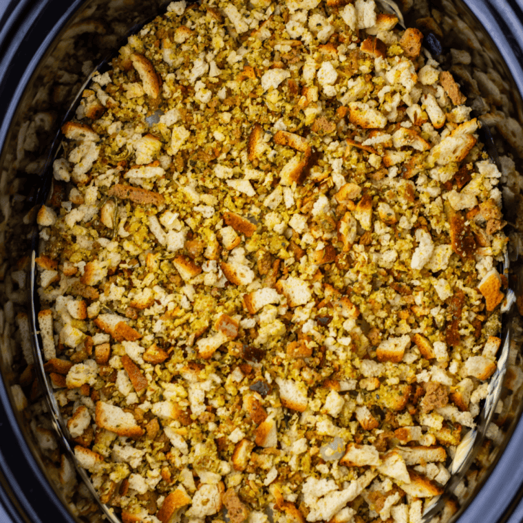 Dry Stove Top stuffing mix sprinkled evenly over the creamy sauce layer in slow cooker chicken and stuffing recipe