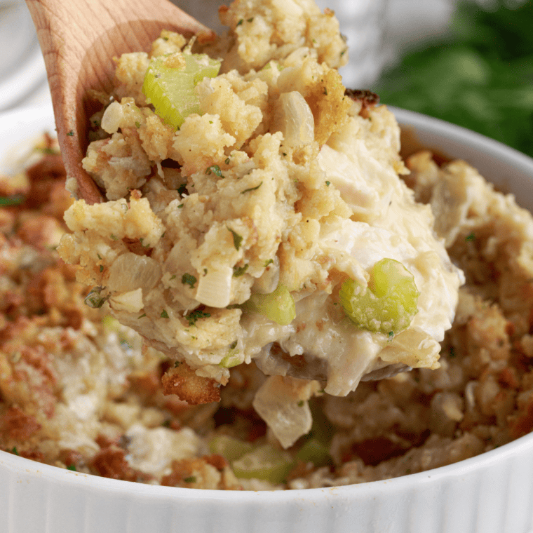 Close-up of crock pot chicken topped with soft stuffing and creamy gravy.