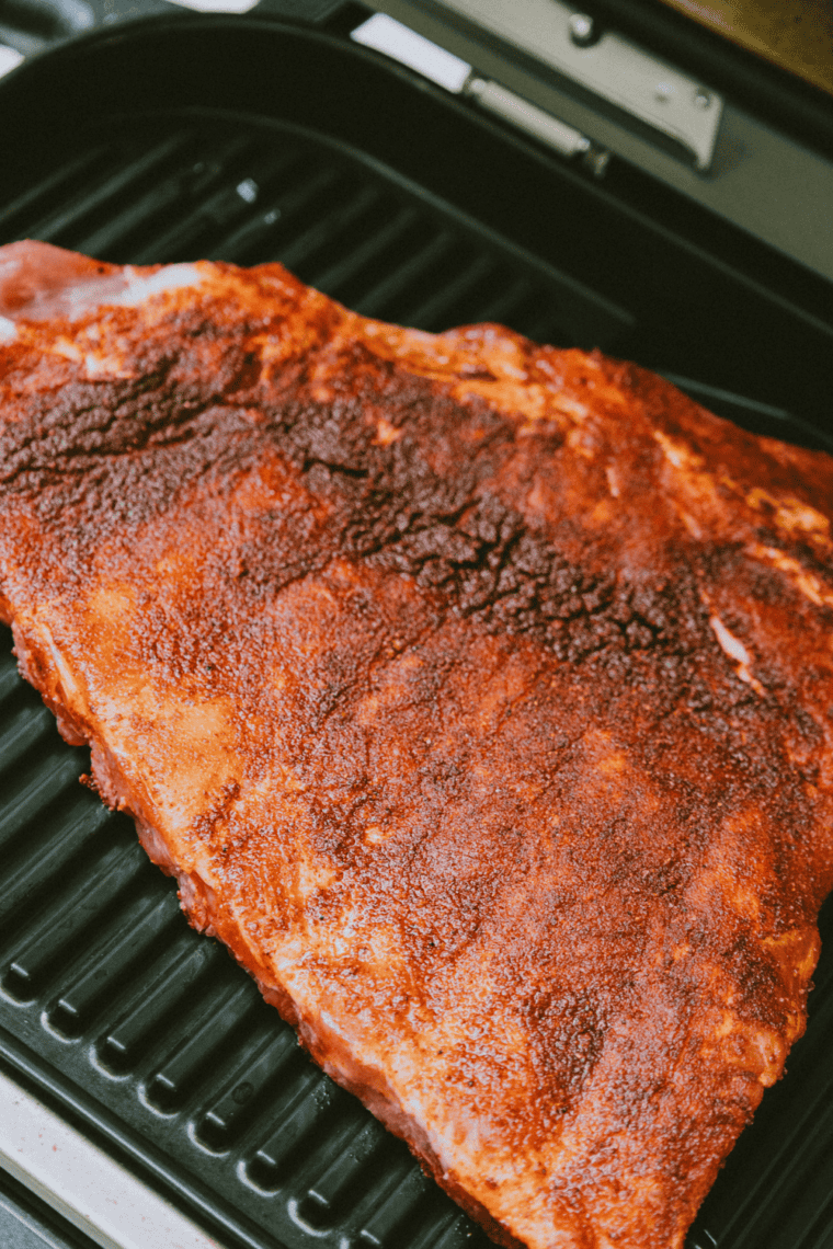 Seasoned beef back ribs cut in half and arranged in a single layer in air fryer basket