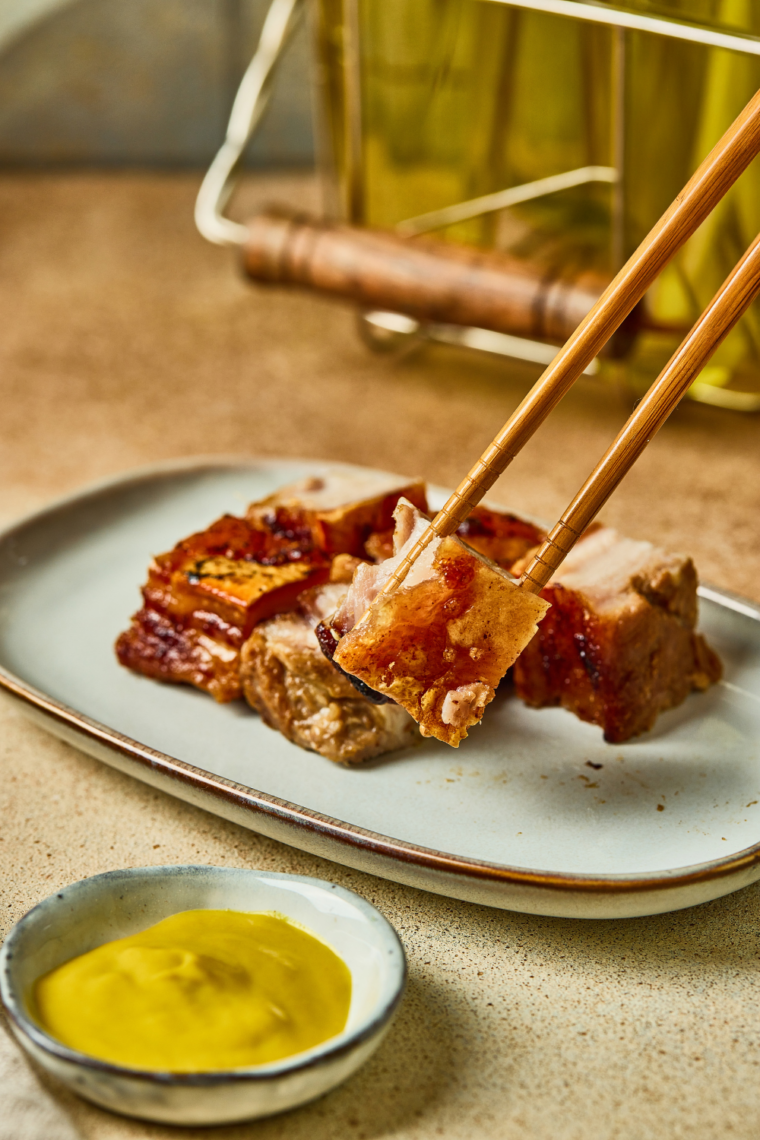 Crispy pork belly skin blistering and bubbling in the air fryer during the final cooking stage.
