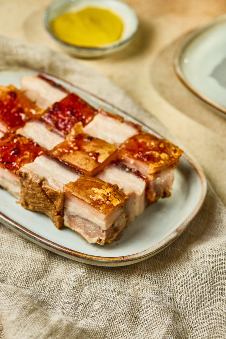 Air fryer roasted pork belly with crispy skin served on a cutting board.