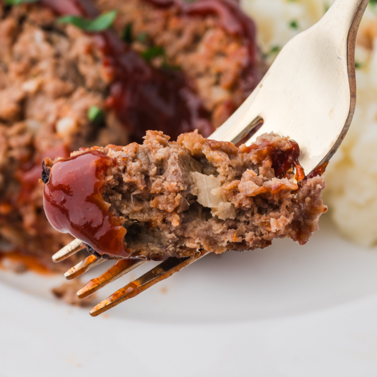Bowl of meatloaf seasoning blend with herbs and spices on wooden table