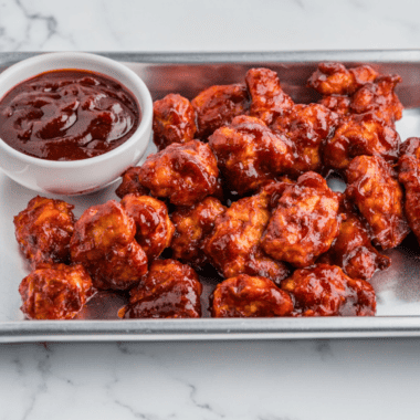 Homemade Burger King BBQ sauce served in a small dipping bowl beside chicken nuggets.