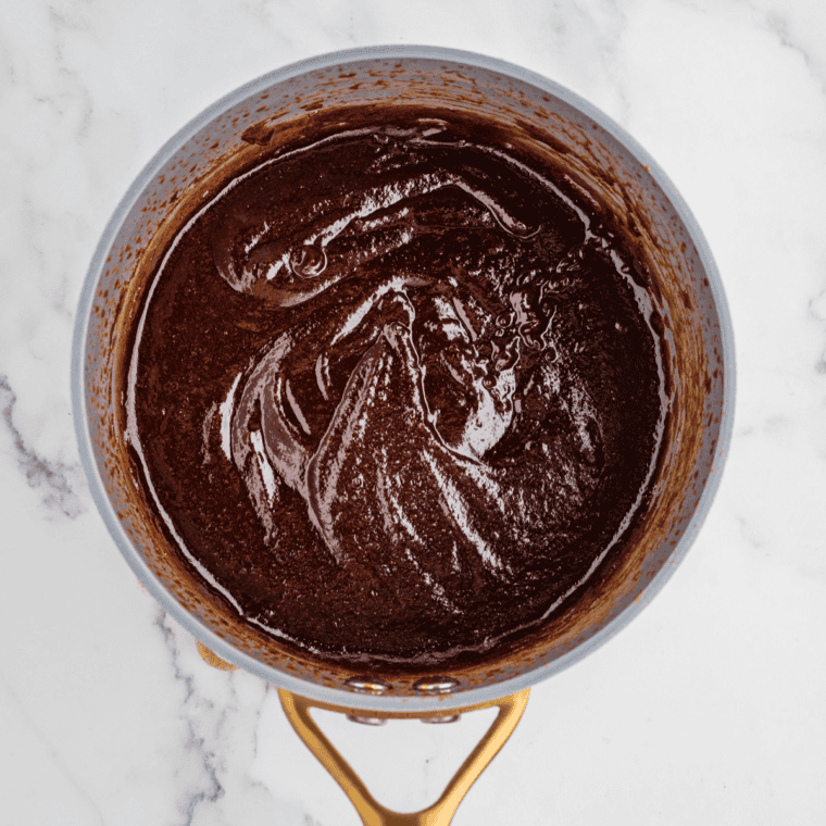 Homemade BBQ sauce simmering on the stove over medium heat until slightly thickened.