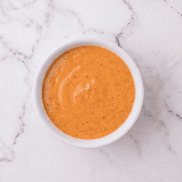 Overhead view of ingredients for Burger King Buffalo Sauce: mayonnaise, hot sauce, ketchup, and spices