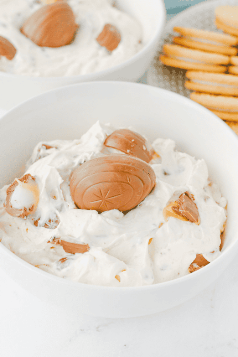 Easter Cadbury Egg dip in a serving bowl surrounded by graham crackers and strawberries