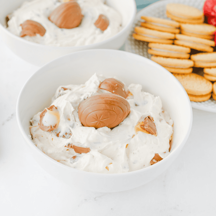 Creamy Cadbury Egg dessert dip topped with crushed mini Cadbury eggs and served with cookies