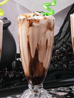 Cold caramel macchiato milkshake in tall glass with caramel swirl and ice cream texture