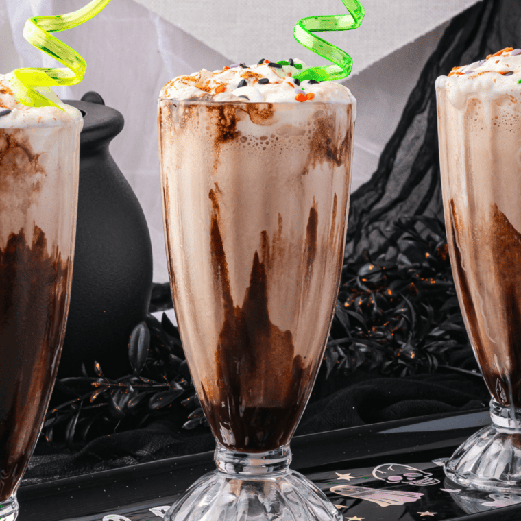 Glass of caramel macchiato milkshake topped with whipped cream and caramel drizzle