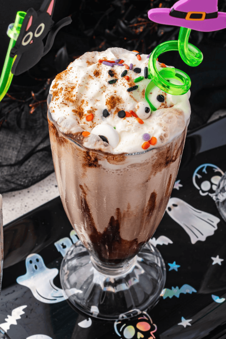 Cold caramel macchiato milkshake in tall glass with caramel swirl and ice cream texture
