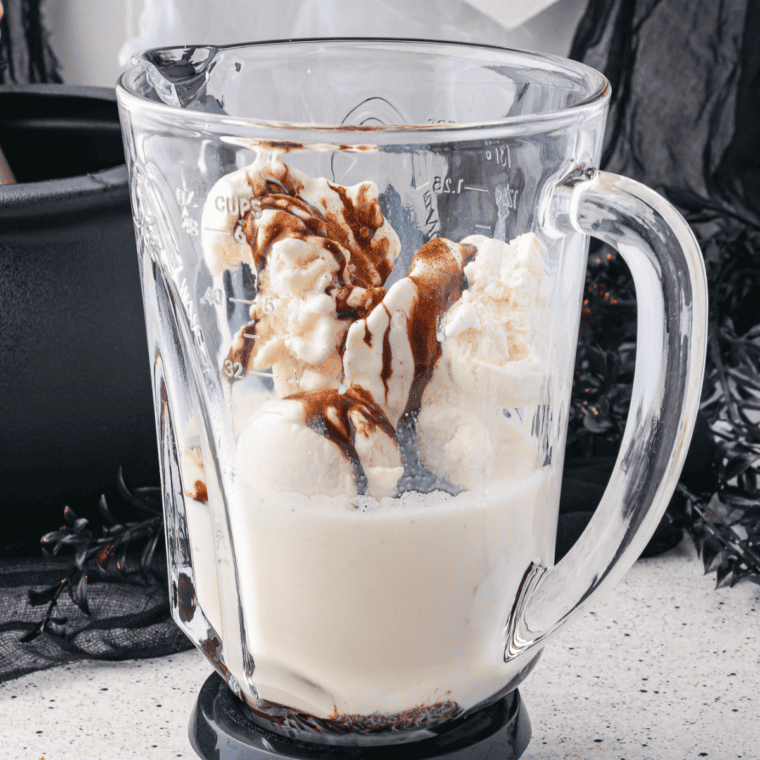 Vanilla ice cream, chilled espresso, caramel sauce, and milk blending in a blender for a Caramel Macchiato Milkshake.