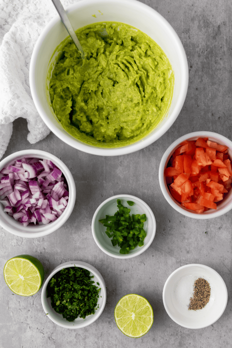 Mashed avocado with visible chunks in a white bowl, showing the perfect Chipotle guacamole texture