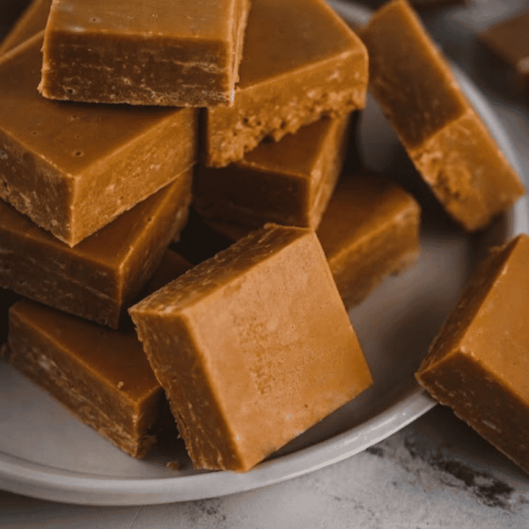 Chocolate and caramel fudge layered and swirled on parchment paper.
