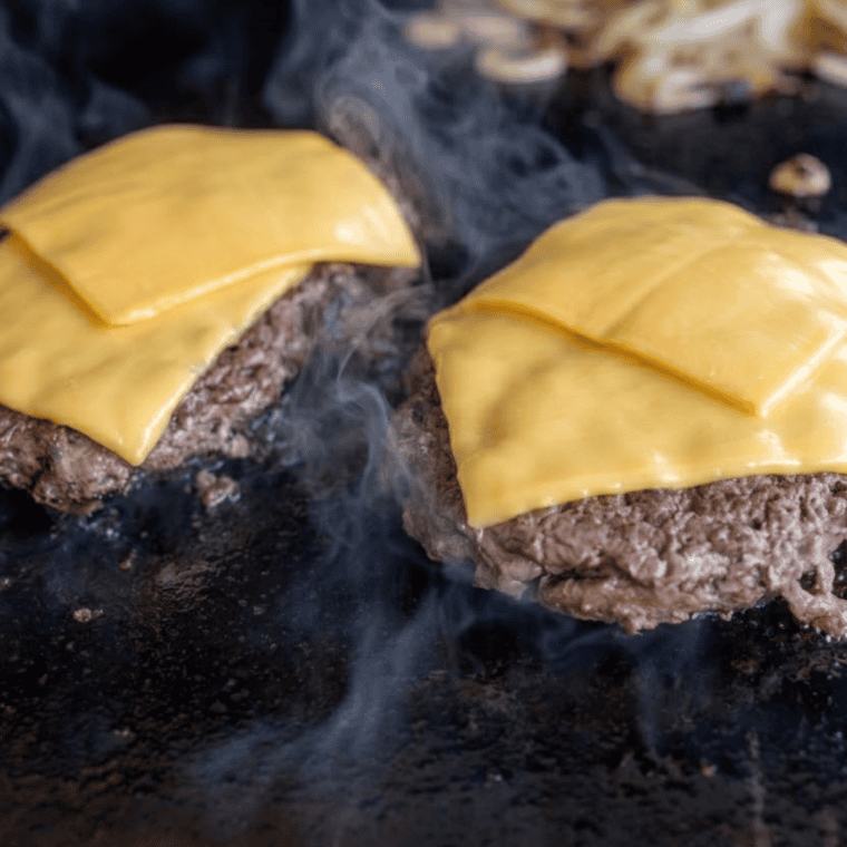 Hamburger buns steaming cut-side down in pan with lid for soft pillowy texture like McDonald&rsquo;s buns