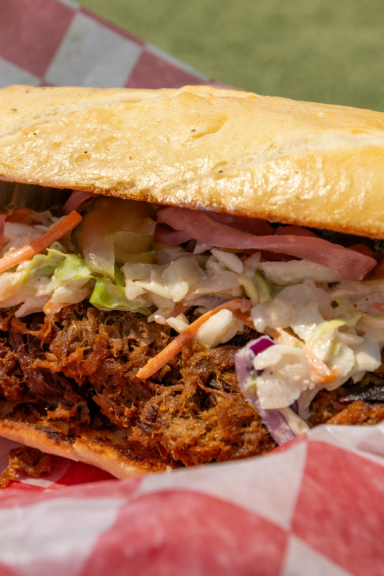 Serving bowl of chilled creamy coleslaw alongside fried chicken and picnic-style meal