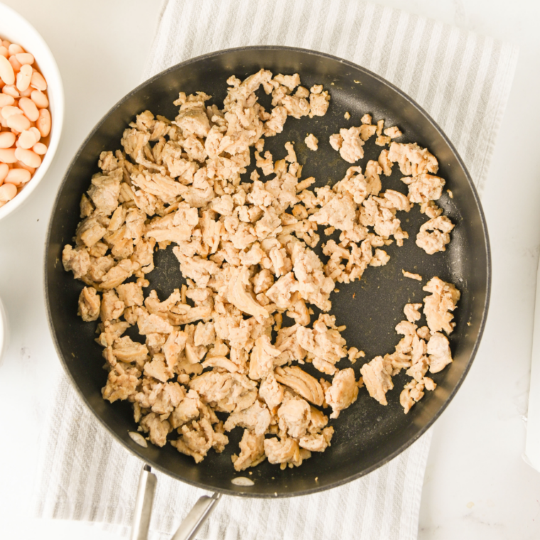 Browning ground chicken in a skillet over medium-high heat until fully cooked and crumbly for buffalo chicken chili