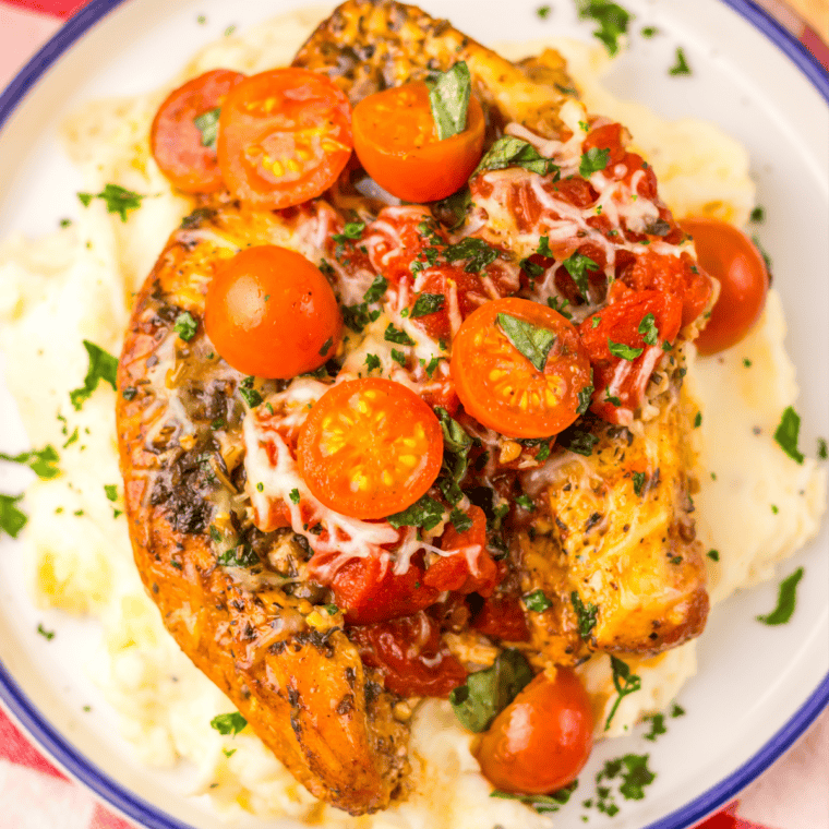 Juicy slow cooker bruschetta chicken with melted mozzarella and fresh balsamic cherry tomato bruschetta topping.