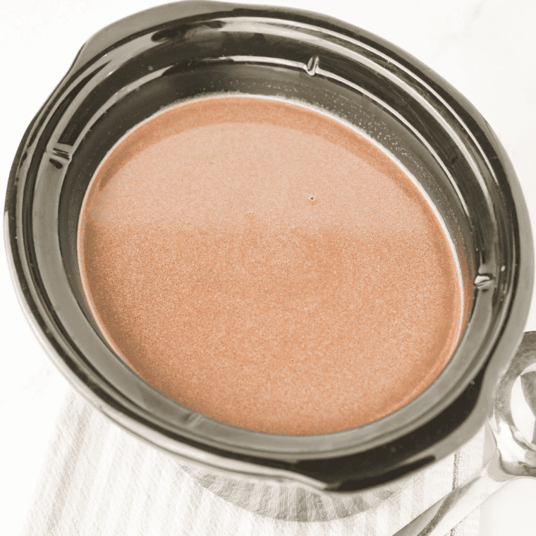 Whisking creamy peppermint hot chocolate in a crockpot as the chocolate melts