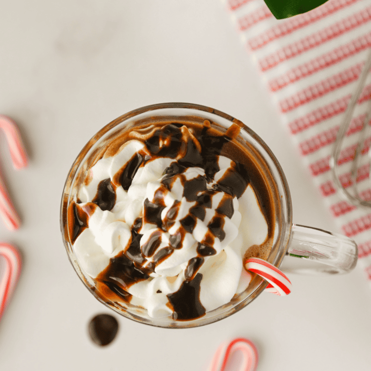 Crockpot hot chocolate with peppermint swirl in a white mug on a festive table