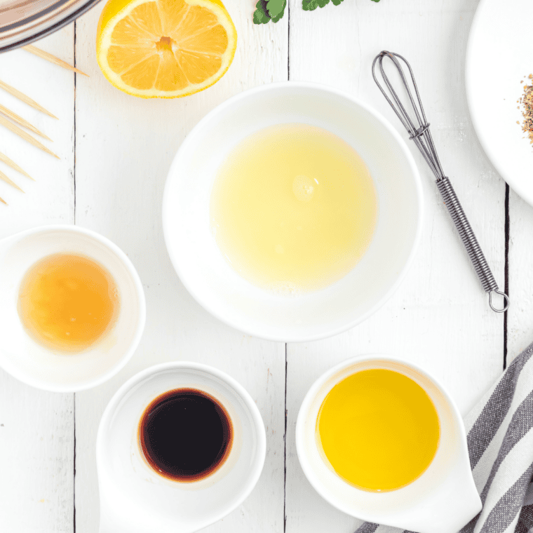 Greek tofu marinade being whisked in a bowl with olive oil, lemon juice, garlic, and oregano