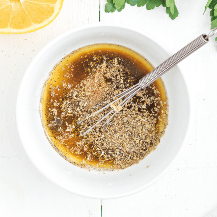 Whisk the marinade until fully blended—olive oil, fresh lemon juice, garlic, and oregano come together into a smooth, fragrant Greek-inspired mix.
