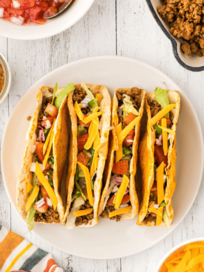 Homemade McCormick taco seasoning copycat in a small glass jar with a measuring spoon on a wooden board